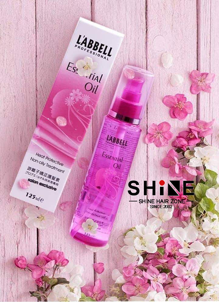 L'ABBELL Professional Essential Oil 125ml heat protect leave-in treatment — bottle and box on pink background