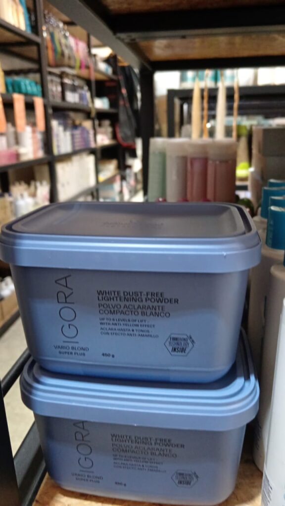 Two stacked 450g light blue tubs of IGORA Vario Blond Super Plus White Dust-Free Lightening Powder on a retail shelf.